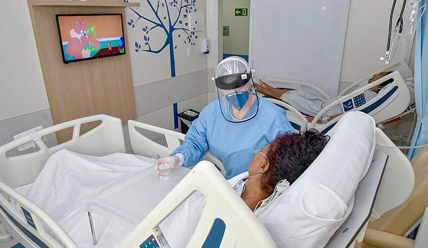 Enfermeira cuidando de paciente em quarto hospitalar
