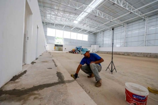 Trabalhador finaliza detalhes no Centro de Excelência do Basquete Ovídeo Bueno, em Jundiaí, com estruturas modernas e espaço amplo.