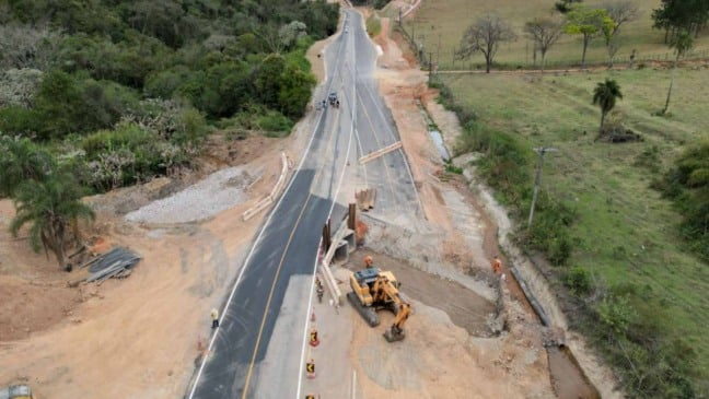 Vista aérea das obras de duplicação da Serrinha em Cabreúva, com trecho asfaltado, máquinas escavadeiras e trabalhadores em atividade na rodovia.