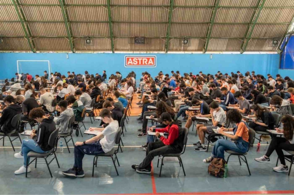 Alunos realizando prova da Olimpíada de Matemática Astra em ginásio lotado em Jundiaí.