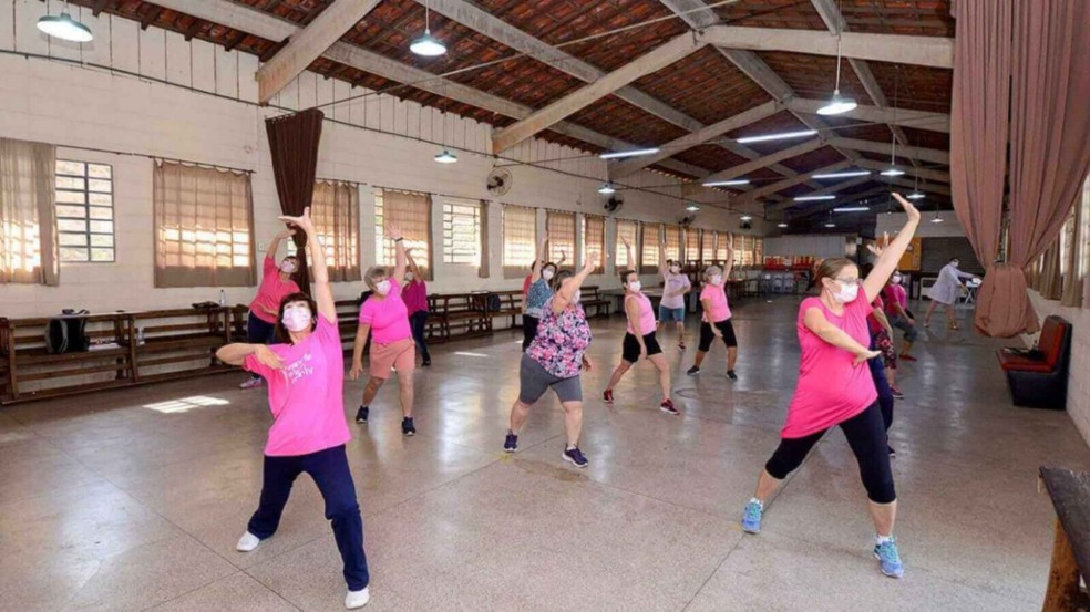 Mulheres reunidas em um galpão para fazer aulas de Liang Gong