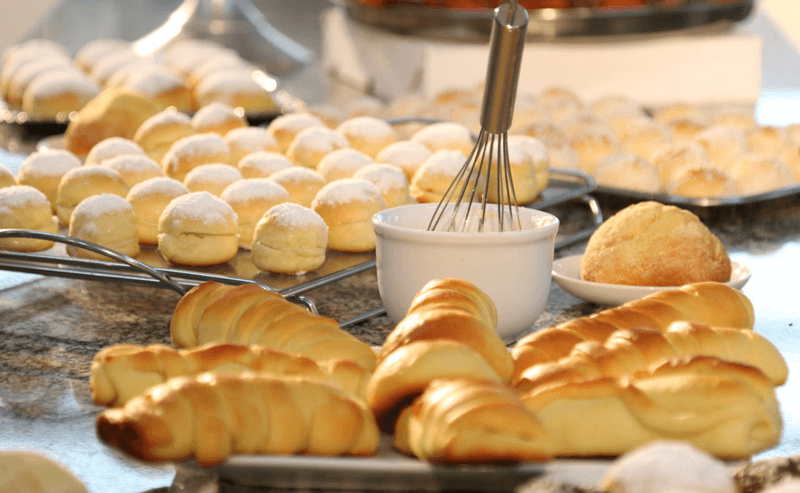 Pães e alimentos de confeitaria expostos em mesa