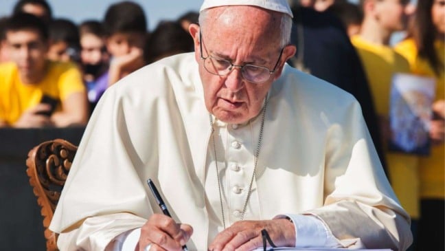 Papa Francisco escrevendo mensagem.