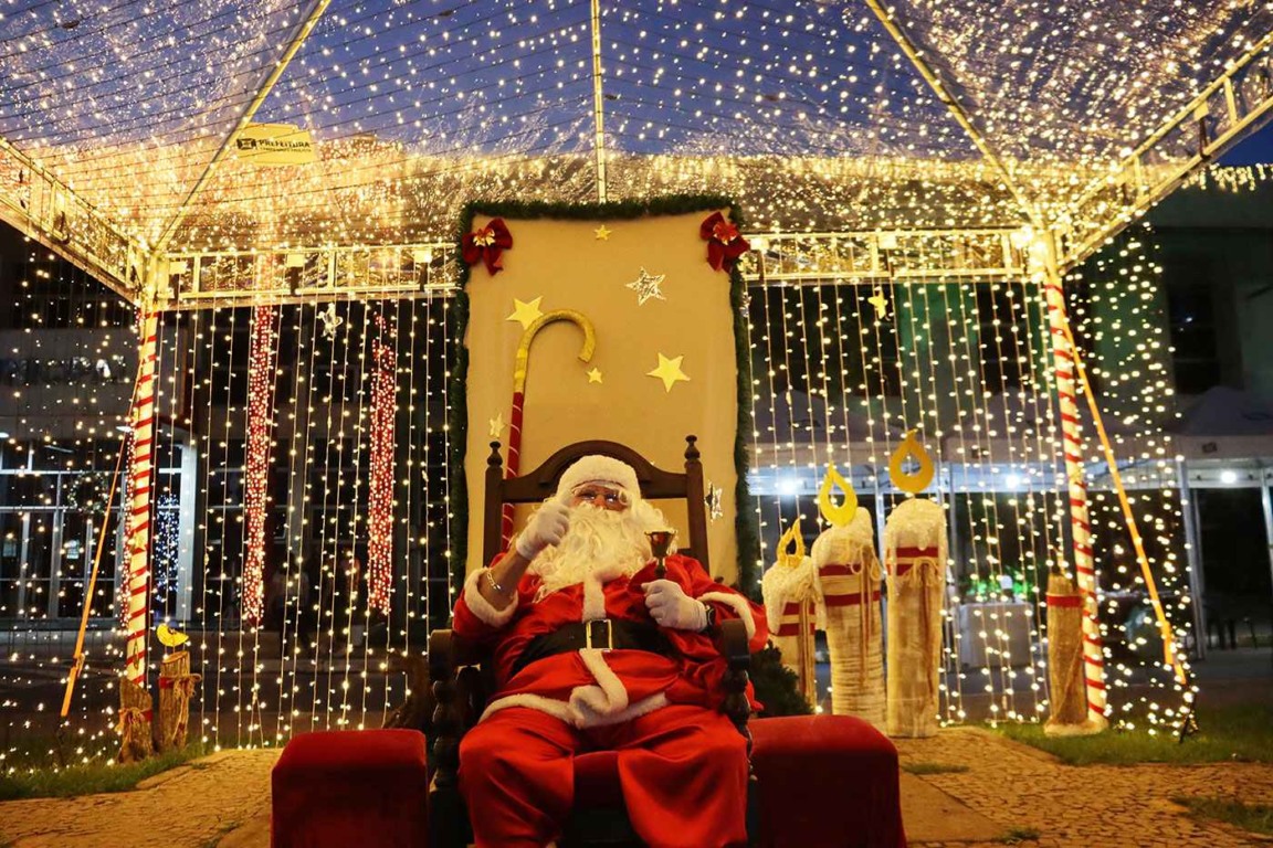 Papai Noel sentado em sua cadeira com fundo iluminado