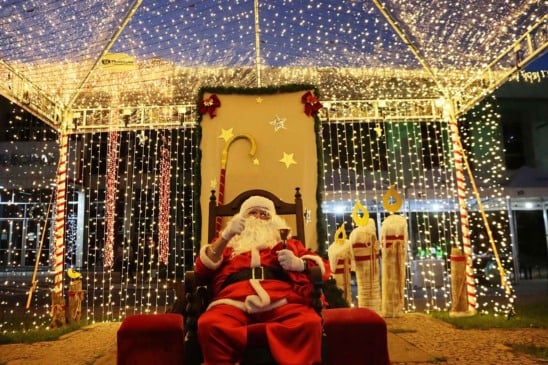 Papai Noel sentado em sua cadeira com fundo iluminado