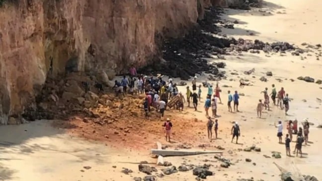 Pessoas aglomeradas ao redor de falésia que desabou em Pipa, no RN