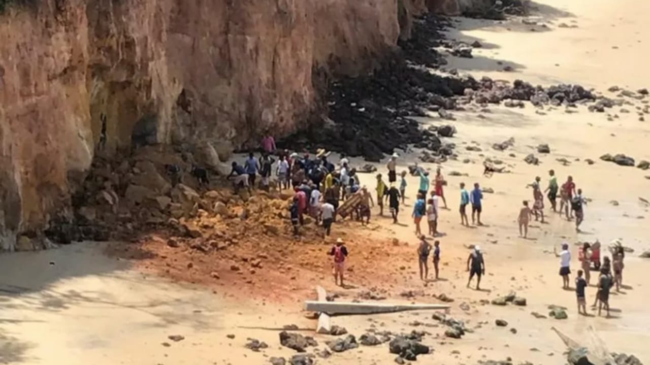 Pessoas aglomeradas ao redor de falésia que desabou em Pipa, no RN