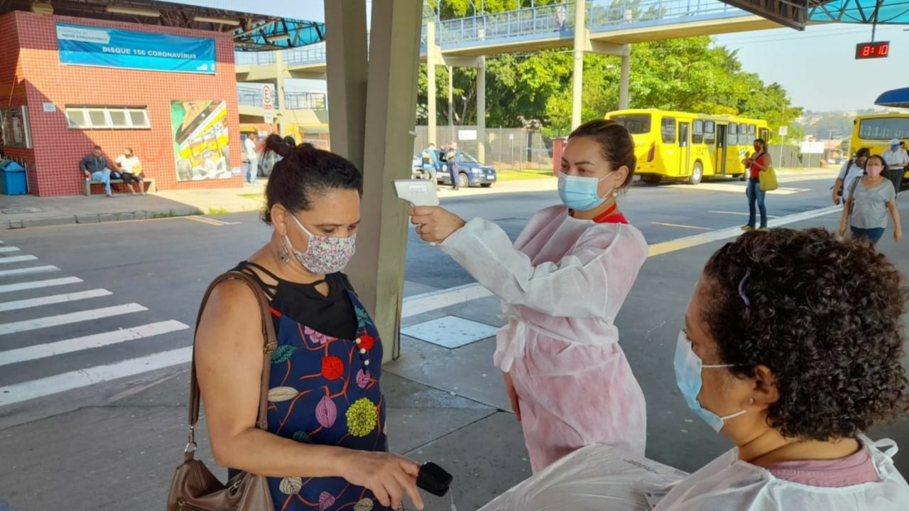 Profissional aferindo temperatura de passageira no Terminal Hortolândia, em Jundiaí