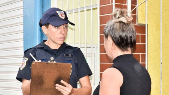 Policial conversa com mulher.