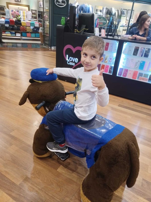 Menino em carrinho de brinquedo