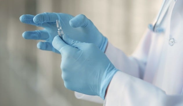 Foto de pessoa segurando dose de vacina