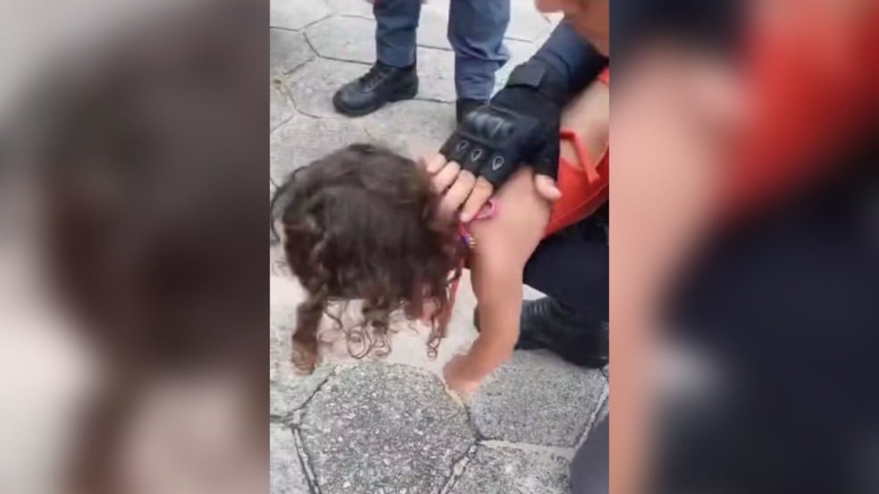 criança sendo salvada por policial.