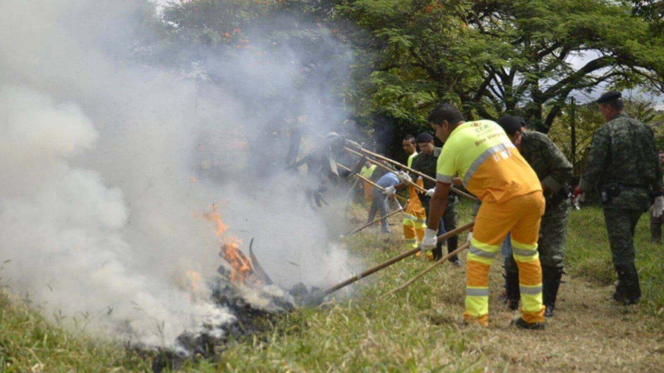 Homens de órgãos municipais combatendo incêndio em área de mata em Jundiaí.
