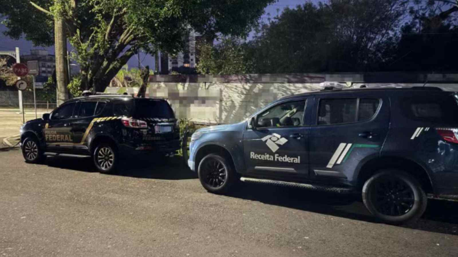Carros da Polícia Federal e da Receita Federal estacionados lado a lado durante operação.