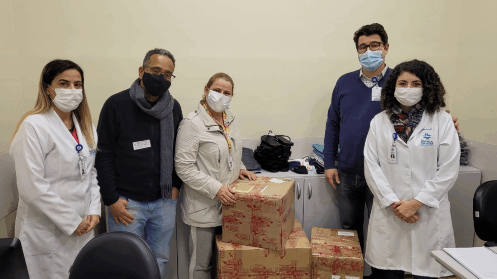 Foto: Equipe do Serviço Social, pastor Ronaldi, Cyzinha e Matheus durante a entrega dos colchões e peças de roupas viabilizados por meio do Bazar do Voluntariado do HSV