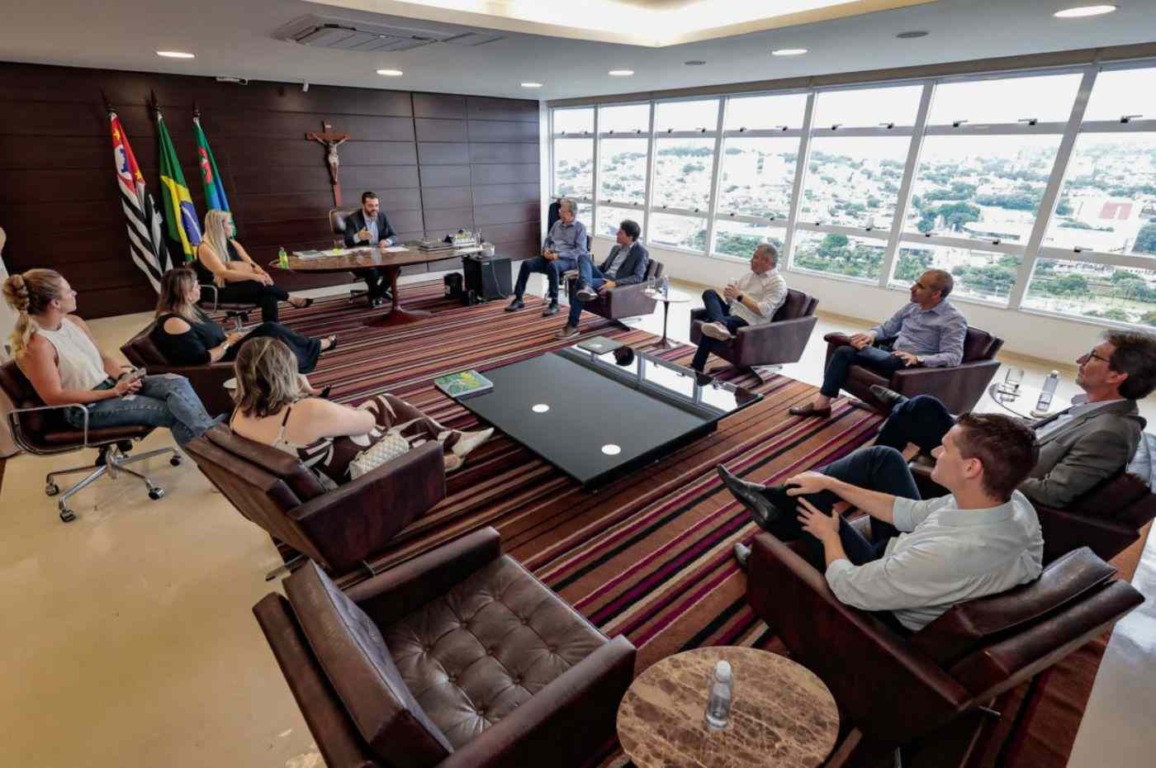 Prefeito de Jundiaí em reunião com representantes da indústria no gabinete, discutindo parcerias e qualificação.