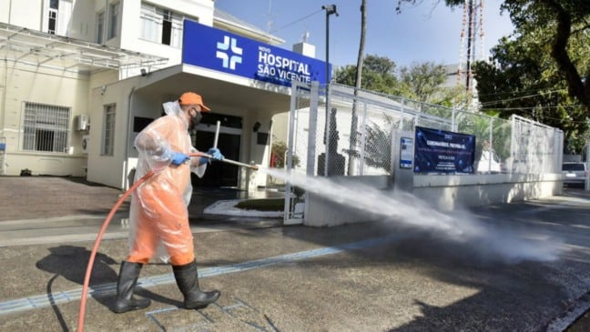 Profissional realizando desinfecção em frente ao Hospital São Vicente, em Jundiaí.