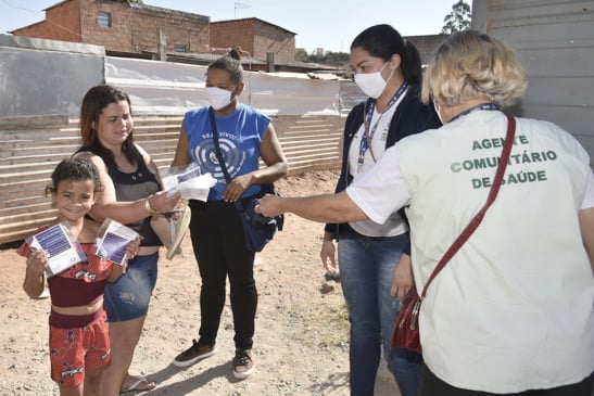 Funcionários da prefeitura entregando máscaras de proteção