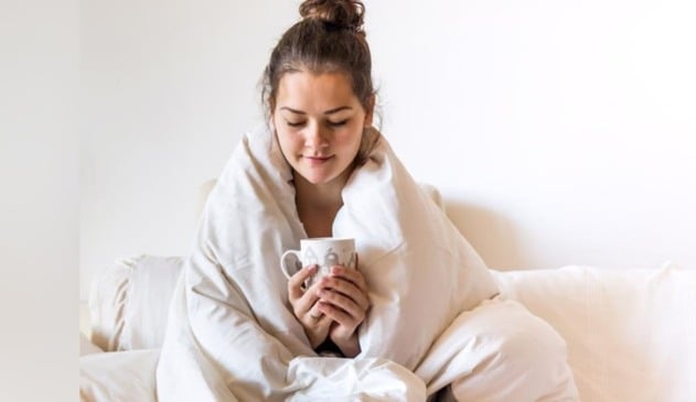 Foto de mulher com coberta e café na mão