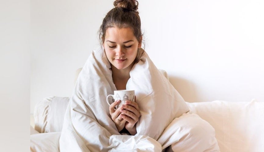 Foto de mulher com coberta e café na mão