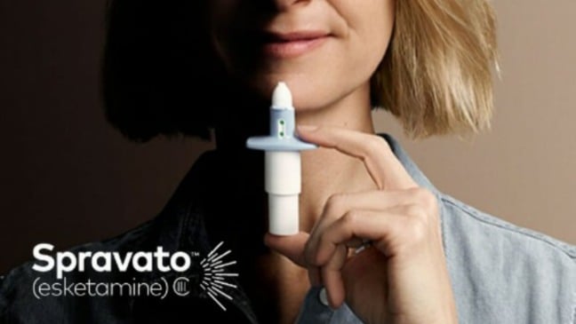 Mulher segurando dose de Spravato, spray nasal contra depressão.