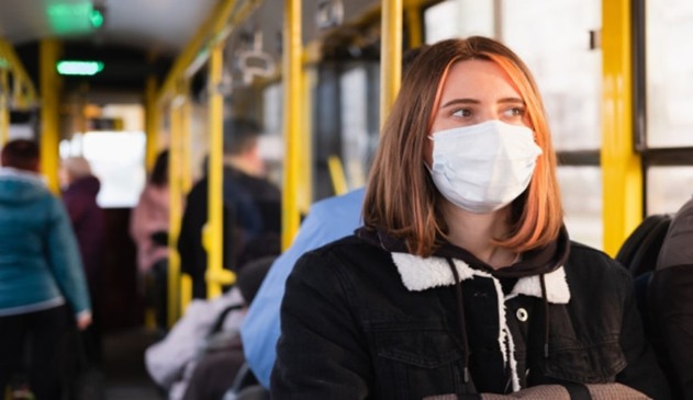 Mulher de máscara em transporte público