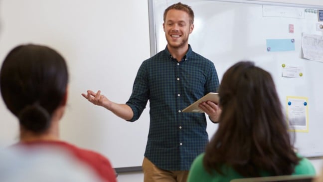 Professor dando aula para dois alunos