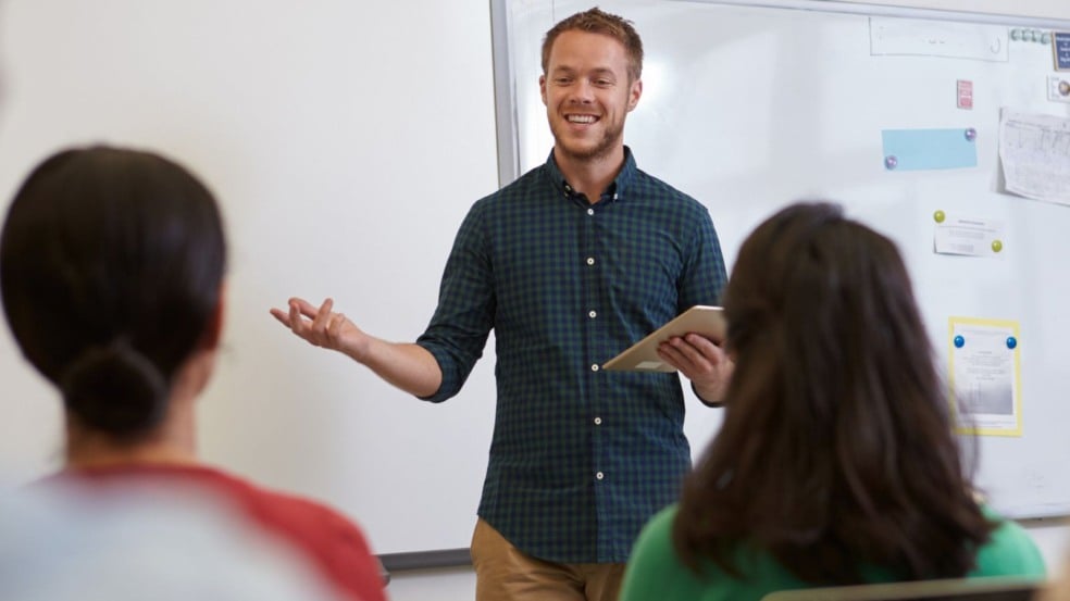 Professor dando aula para dois alunos