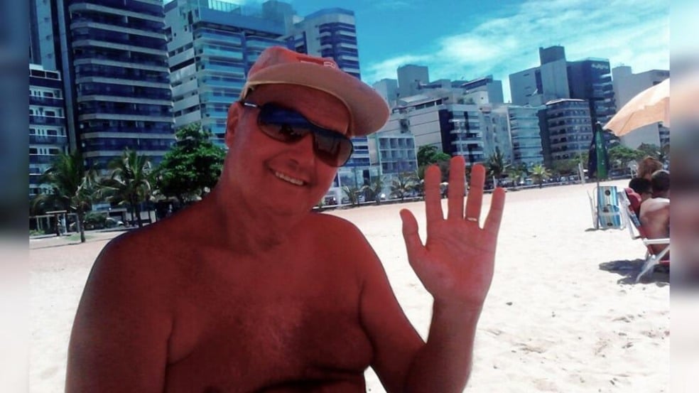 professor Zé Dias na praia acena para a fotografia