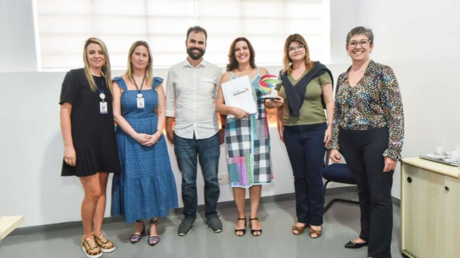 Mara (com o prêmio em mãos) reuniu inglês e solidariedade em trabalho premiado