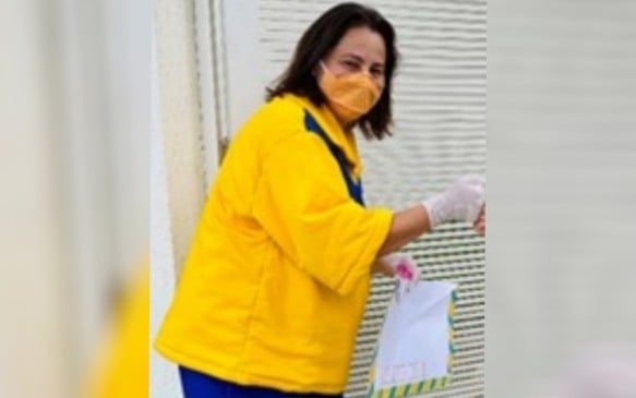 Professora se veste de carteira para entregar mensagens e matar saudade dos alunos.