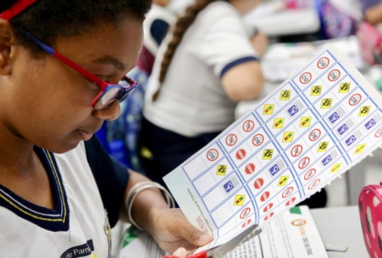 Aluna faz trabalho de educação no trânsito com tesoura e gravuras