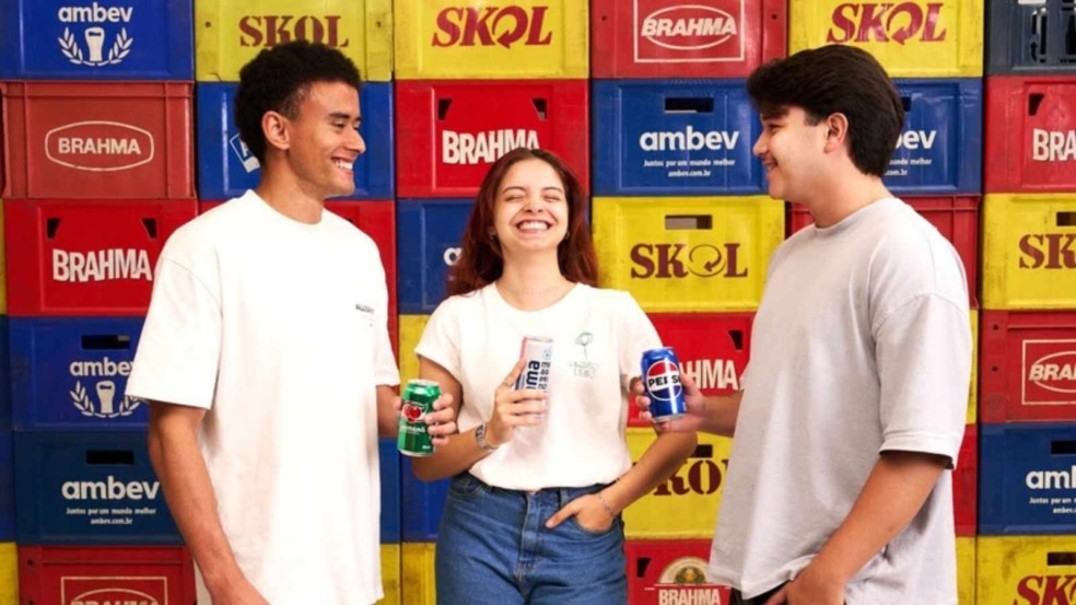 Jovens segurando latas de refrigerante.