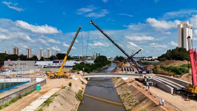 dois guindastes levantando vigas de concreto para construção de ponte em Jundiaí