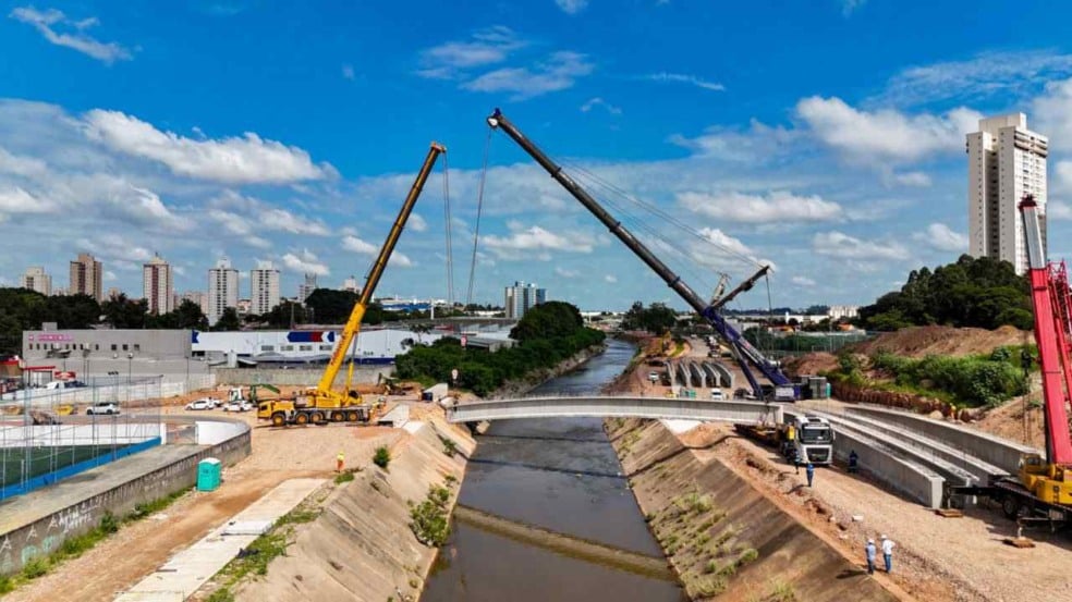 dois guindastes levantando vigas de concreto para construção de ponte em Jundiaí