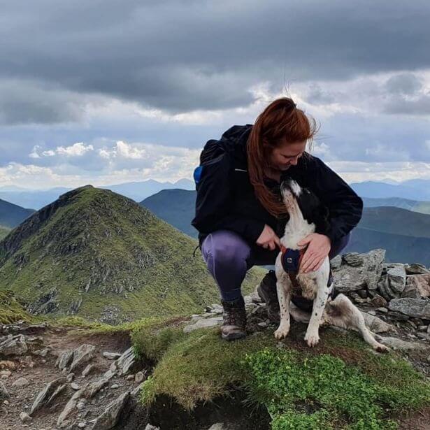 Mulher e cachorro em montanha