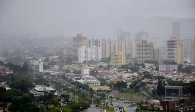Vista da cidade de Jundiaí em um dia nublado e chuvoso, destacando a queda de temperatura em Jundiaí, com prédios encobertos pela neblina.