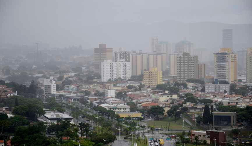 Vista da cidade de Jundiaí em um dia nublado e chuvoso, destacando a queda de temperatura em Jundiaí, com prédios encobertos pela neblina.