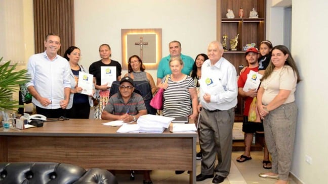 Prefeito com pessoas que receberam a regularização.