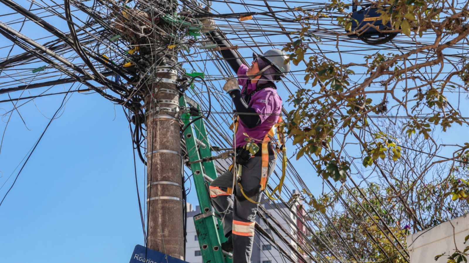 Trabalhador reordenando cabos de telefonia.