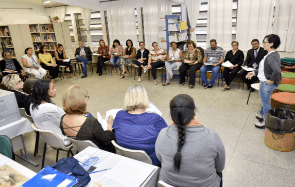 Grupo de pessoas sentado em cadeiras em roda de conversa