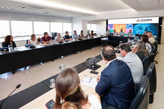 Reunião da Prefeitura de Jundiaí com secretariado discutindo ações de combate à dengue em sala com mesa em U.