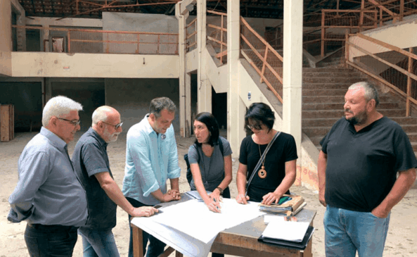 Pessoas em volta de uma mesa discutem projeto de obra