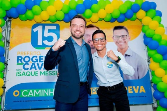 Rogério Cavalin e Isaque Messias comemorando início da campanha de reeleição em Itupeva, com banner e balões ao fundo.