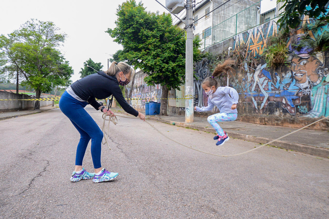 Criança pulando corda na rua