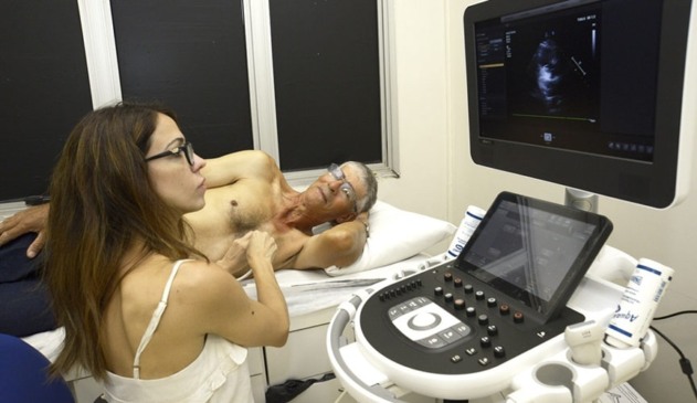 Foto de homem deitado em maca para realizar exame de coração