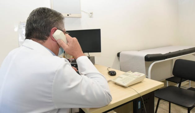 Médico atendendo pacientes com Covid-19 por telefone