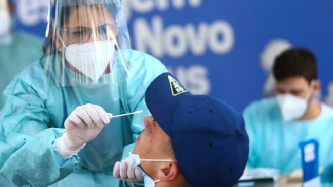 Mulher administrando teste de Covid em homem