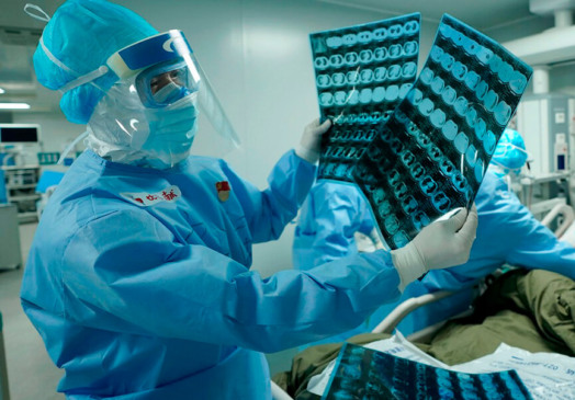 Médico examina tomografias em hospital de Wuhan, na China. (Foto: Wang Yuguo / Xinhua via AP)