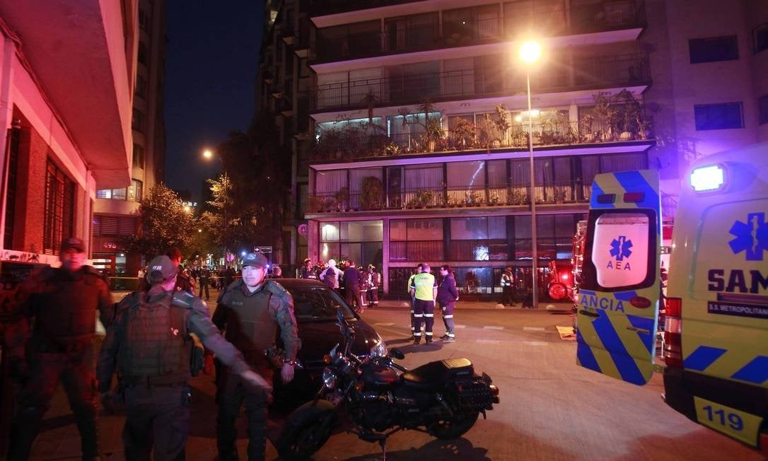 Policiais e equipes de resgate cercam edifício no qual seis turistas brasileiros morreram, no centro de Santiago Foto: El Mercurio/Agência O Globo